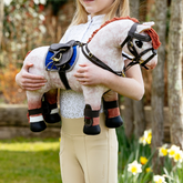 Person holding a toy pony wearing the LeMieux Toy Pony Jump Saddle & Stud Girth
